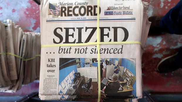 FILE - A stack of the Marion County Record sits in the back of the newspaper's building, awaiting unbundling, sorting and distribution, Aug. 16, 2023, in Marion, Kan. A former reporter for a weekly Kansas newspaper has agreed to accept $235,000 to settle part of her federal lawsuit over a police raid on the paper that made a small town the focus of a national debate over press freedoms. (AP Photo/John Hanna, File) Bound stack of Marion County Record newspapers with the front-page headline: "SEIZED .. but not silenced"