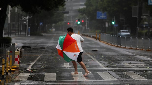 A person braves strong wind and rain as Super Typhoon Ragasa approaches in Shenzhen, Guangdong Province, China September 24, 2025. REUTERS/Go Nakamura TPX IMAGES OF THE DAY Typhoon Ragasa in Shenzhen, China