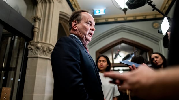 man speaks to reporters