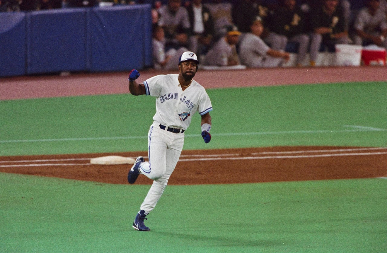 A baseball player runs along the bases at a ballgame