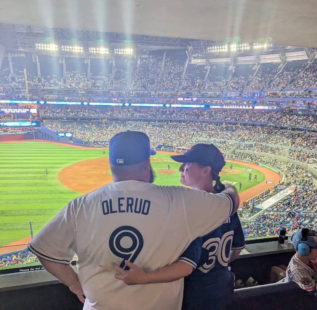 Two radical wearing Blue Jays jerseys watching a shot game