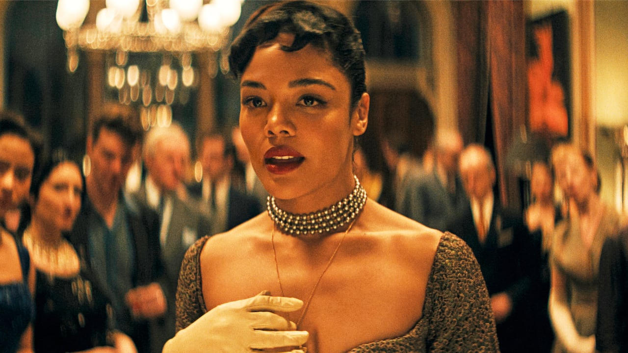 A pistillate   successful  1950s play  ballroom formal  stands successful  beforehand   of a crowd. 