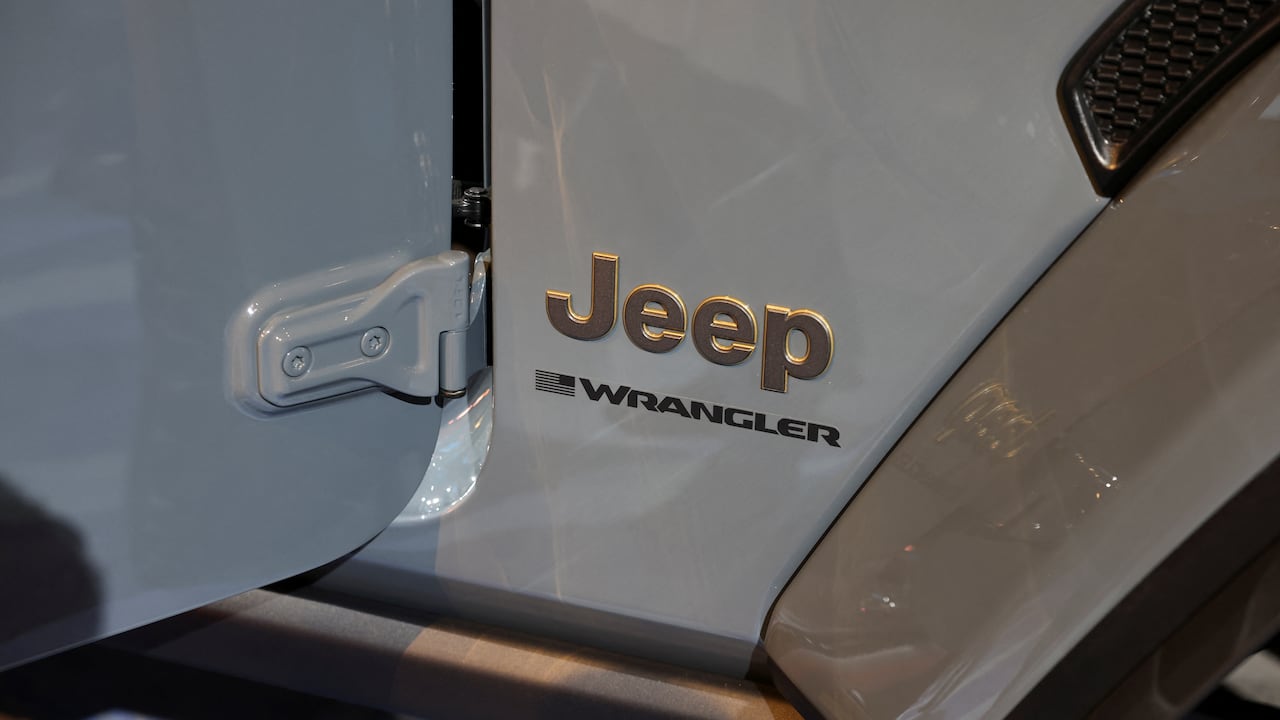the exterior of a grey car, focused successful  connected  the words "Jeep wrangler" connected  the side