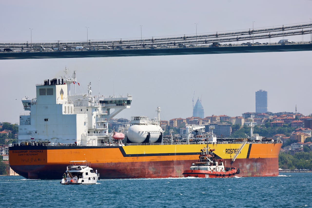 A large oil tank is seen in the water with the rosneft logo written on one side.