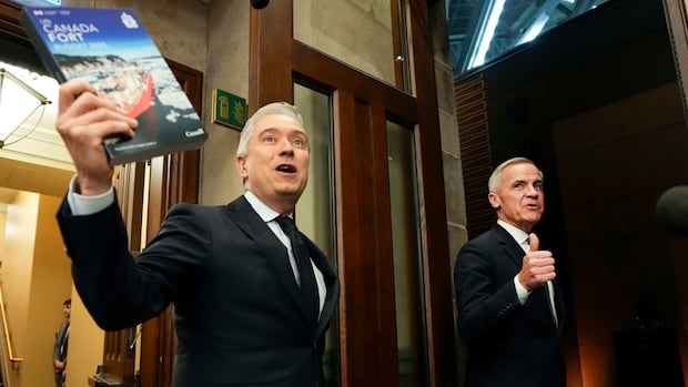 Two men hold up books