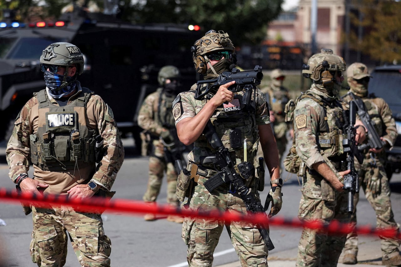Heavily armed officers stand on a city street