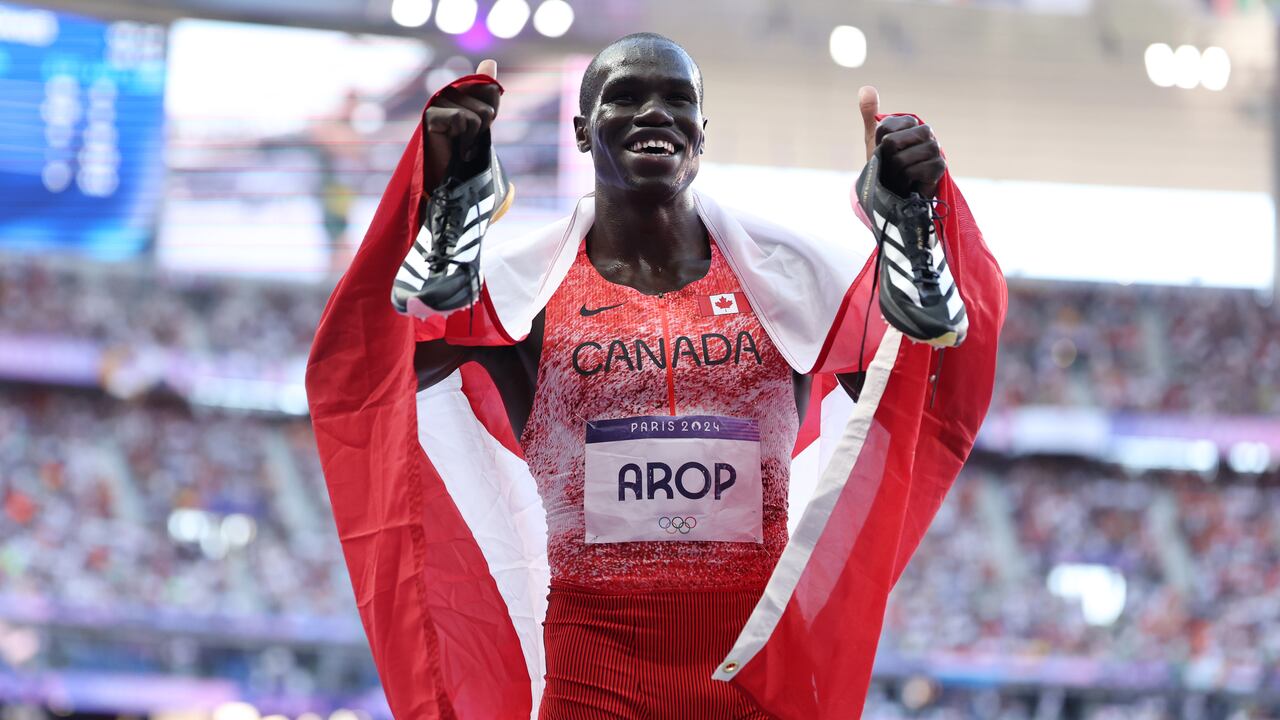 Man smiling with canadian flag after winning olympic medal
