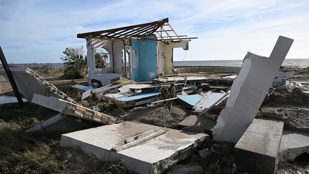A building is seen damaged following the passage of Hurricane Melissa, in Black River, St. Elizabeth, Jamaica on October 29, 2025. Hurricane Melissa bore down on the Bahamas October 29 after cutting a path of destruction through the Caribbean, leaving 30 people dead or missing in Haiti and parts of Jamaica and Cuba in ruins.  Somewhat weakened but still threatening, Melissa will bring damaging winds and flooding rains to the Bahamas Wednesday before moving on to Bermuda late Thursday, according to the US National Hurricane Center (NHC). (Photo by Ricardo Makyn / AFP) (Photo by RICARDO MAKYN/AFP via Getty Images)           An aerial image shows a roof blown off a structure with debris all around