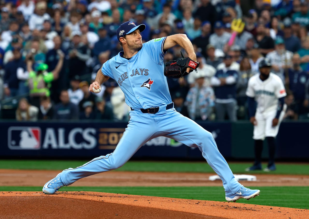 A baseball pitcher in a powder blue uniform throws the ball.