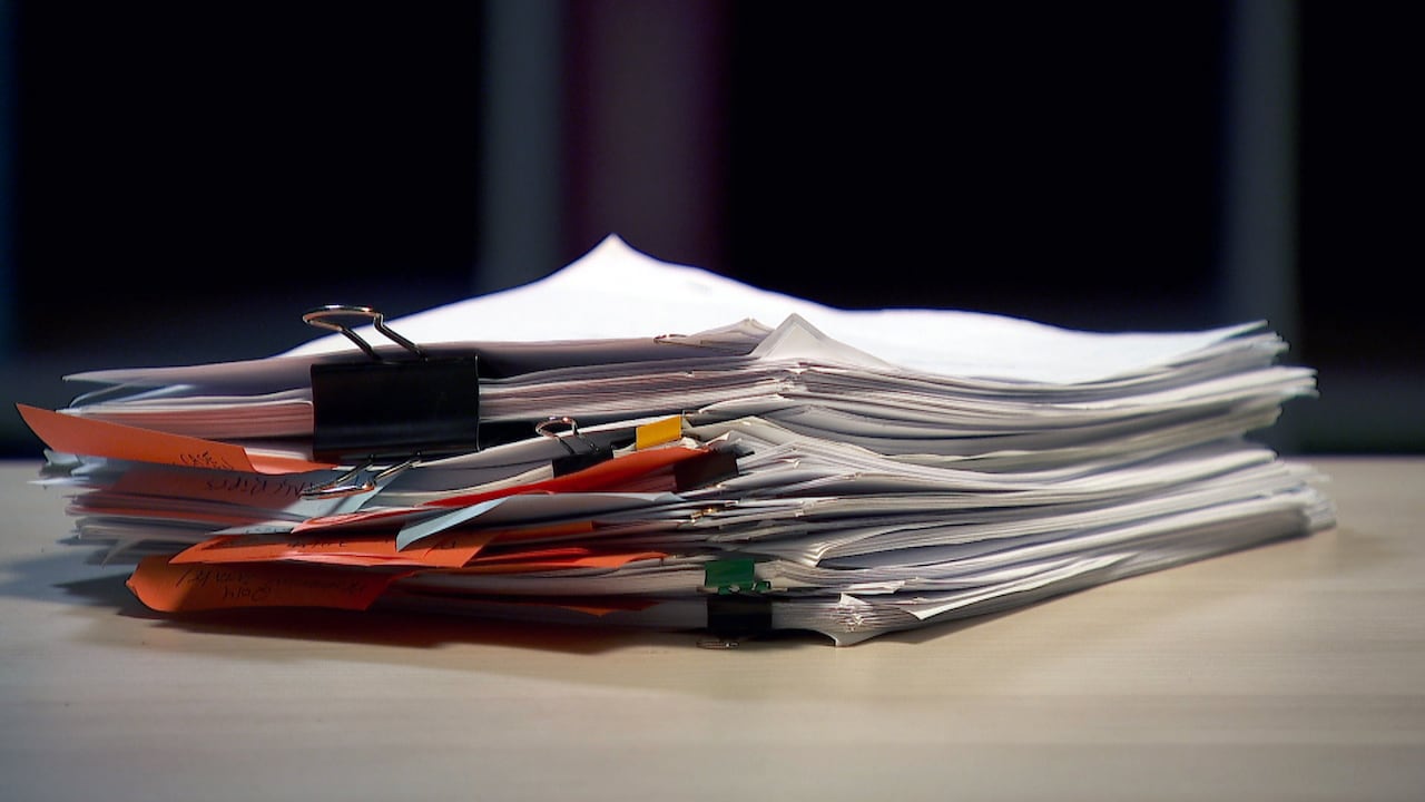 A large pile of documents on a table.