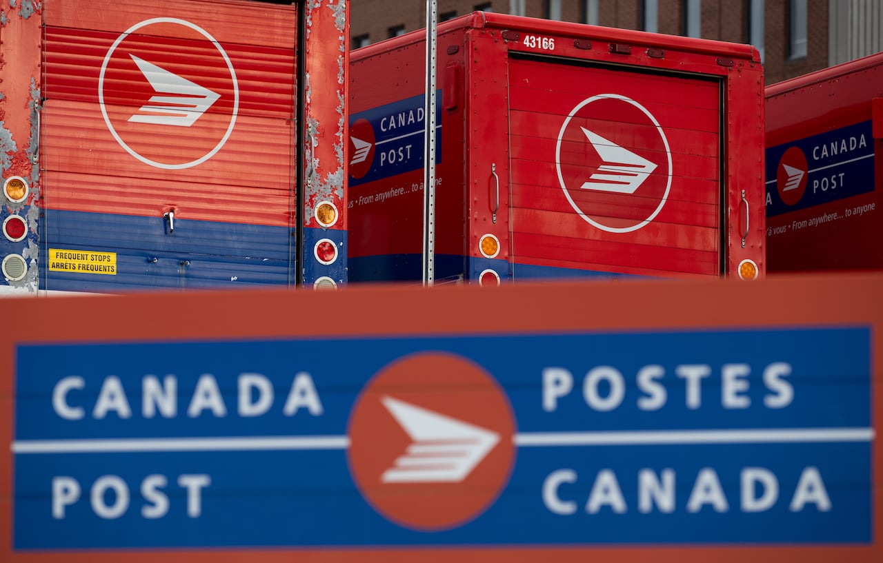 Los carteles de Canada Post y los vehículos estacionados se ven en una instalación de clasificación de correo de Canada Post en Ottawa.