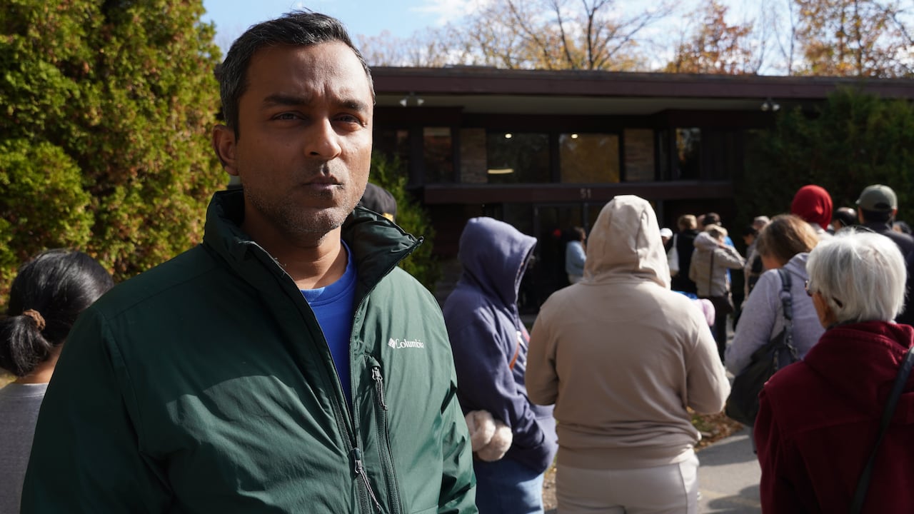 A man stands in line with hundreds of people
