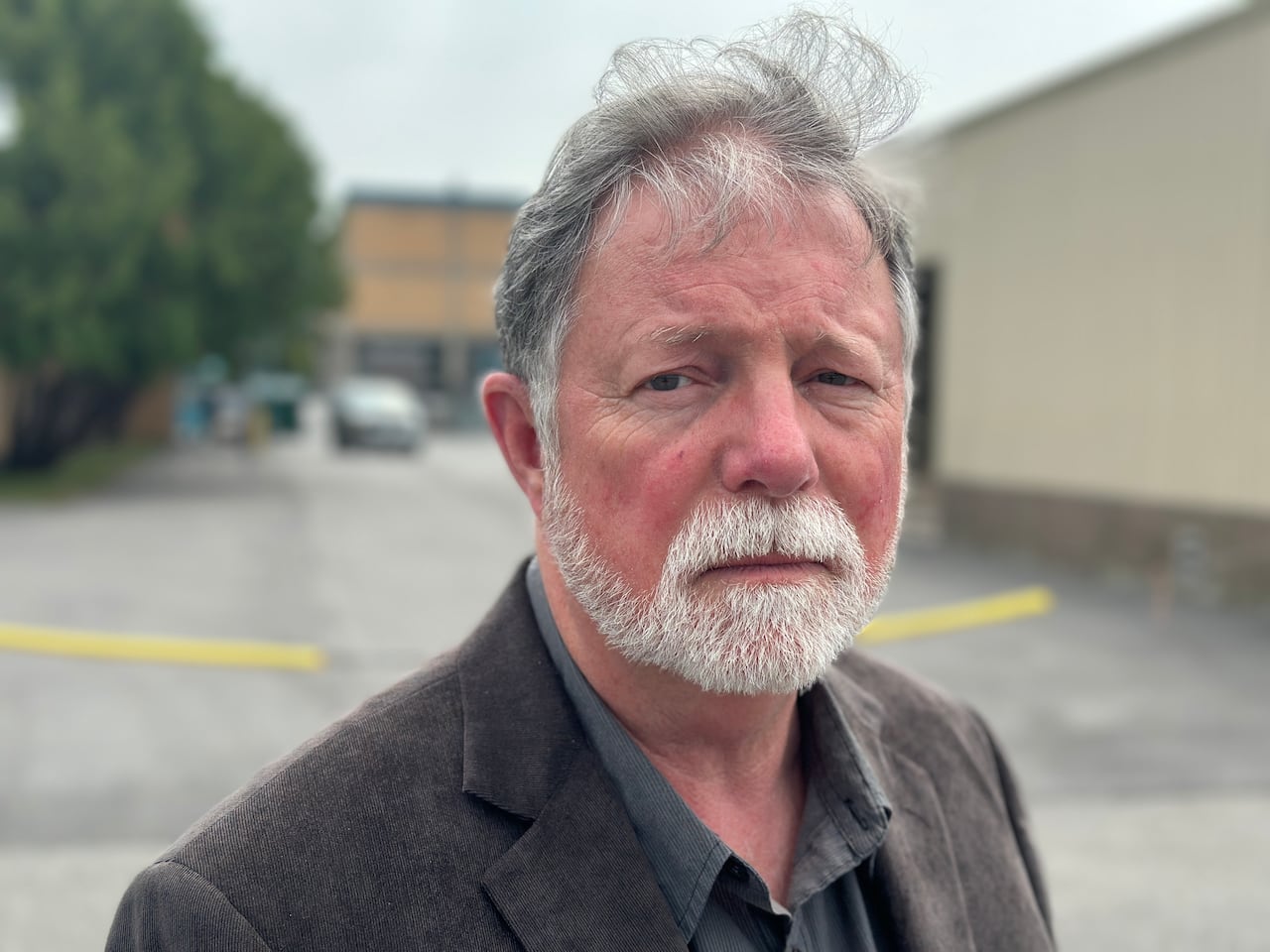 Dennis Curley, a survivor of the 1975 shooting at St. Pius X High School in Ottawa, stands outside the school on Aug. 5, 2025. 'I have relived that day my entire adult life,' Curley says.,