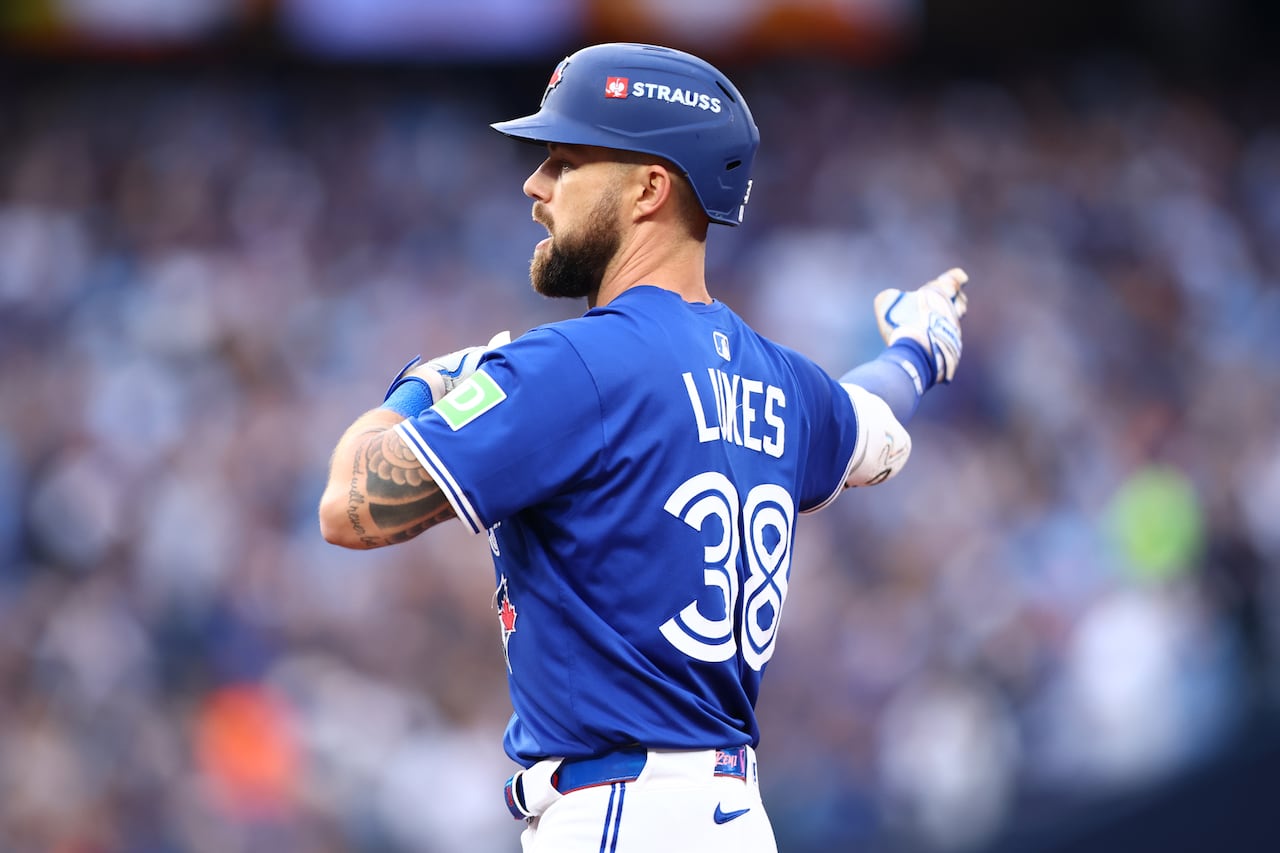 A baseball player pointing away from his body