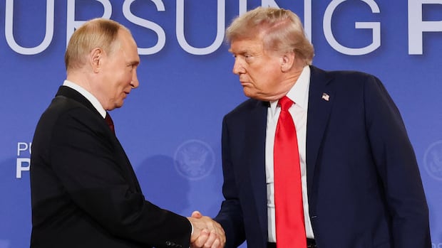 Two men in suits shake hands