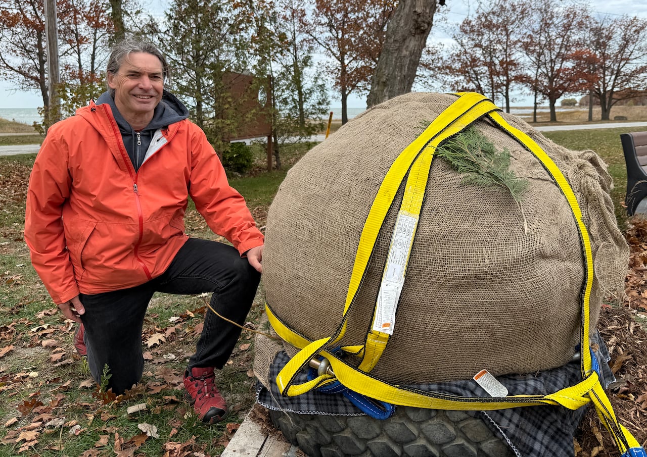 Homem com uma pedra grande embrulhada em estopa.