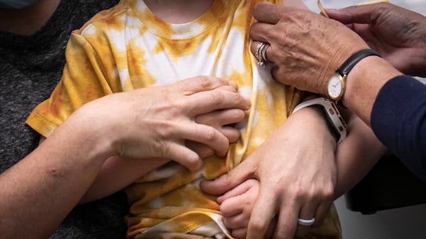 A nurse provides a band aid after delivering a COVID-19 vaccination to a child during the first week of immunization for children between 6 months and 4 years old at a Vancouver Coastal Health clinic in Vancouver, British Columbia on Thursday, August