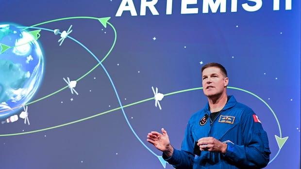 Astronaut Jeremy Hansen speaks about his upcoming Artemis II mission during an event at the Canadian Space Agency, in Longueuil, Que., on Thursday, Oct. 16, 2025. THE CANADIAN PRESS/Graham Hughes A man speaking. Behind him is an image of the earth.