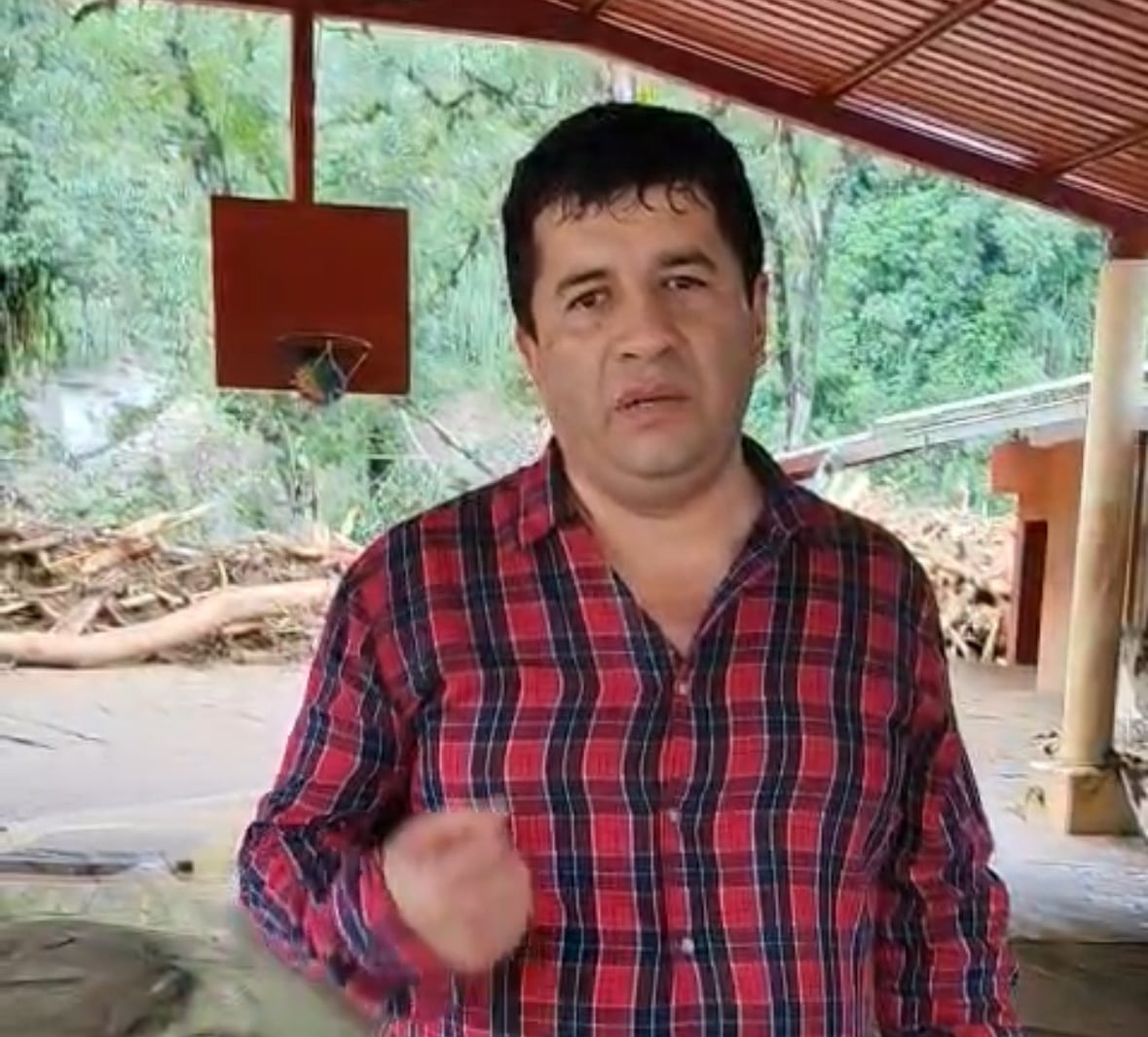 Dark-haired man wearing a plaid shirt.