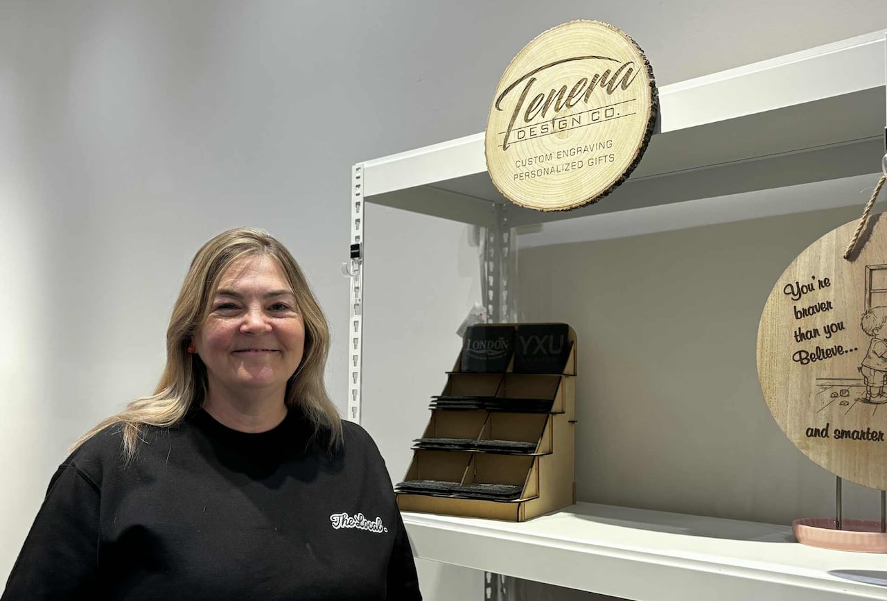 Una mujer sonríe junto a un estante