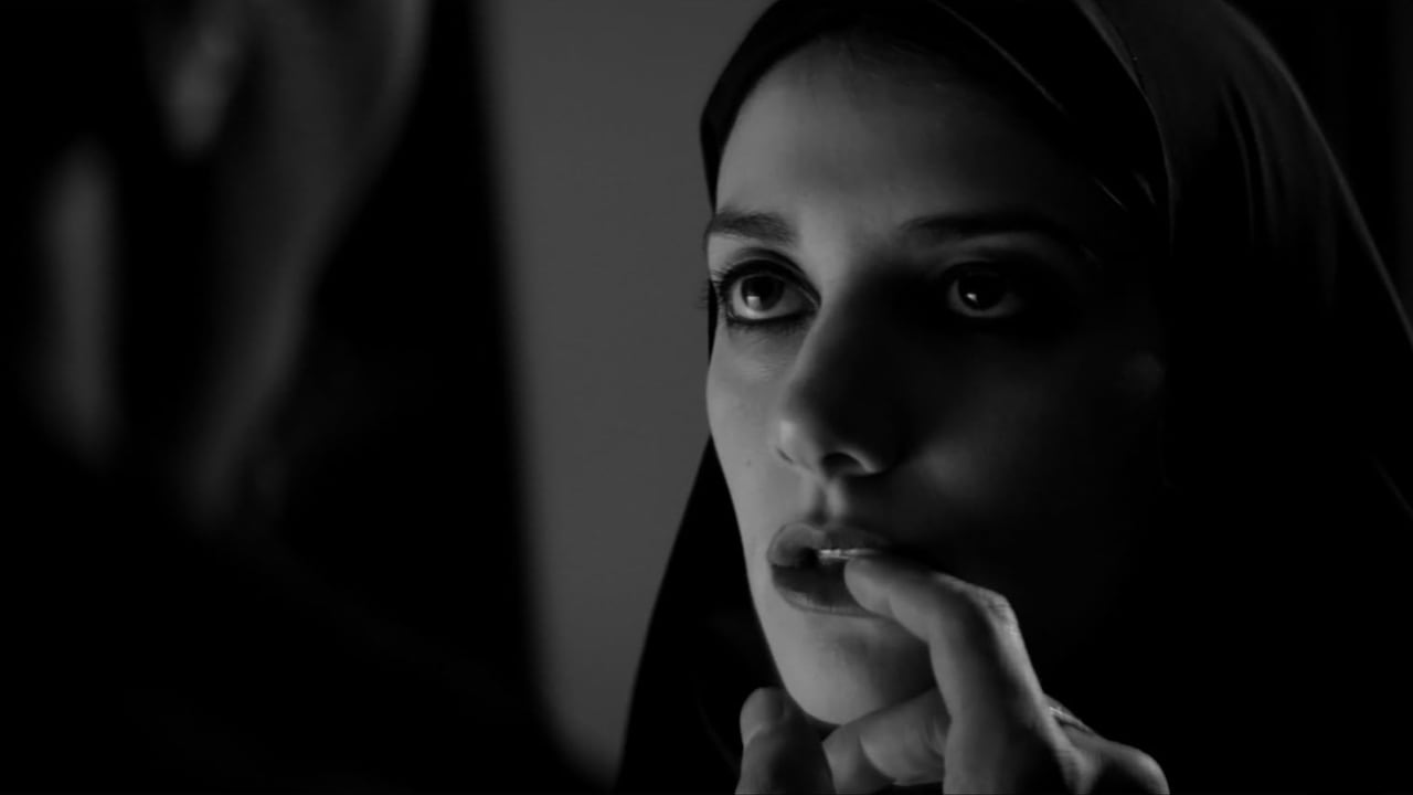 Closeup on a woman's face looking at someone in the foreground who is putting their finger on her lip.