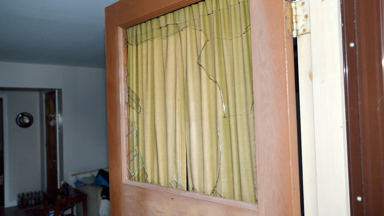 A broken glass window in a door.