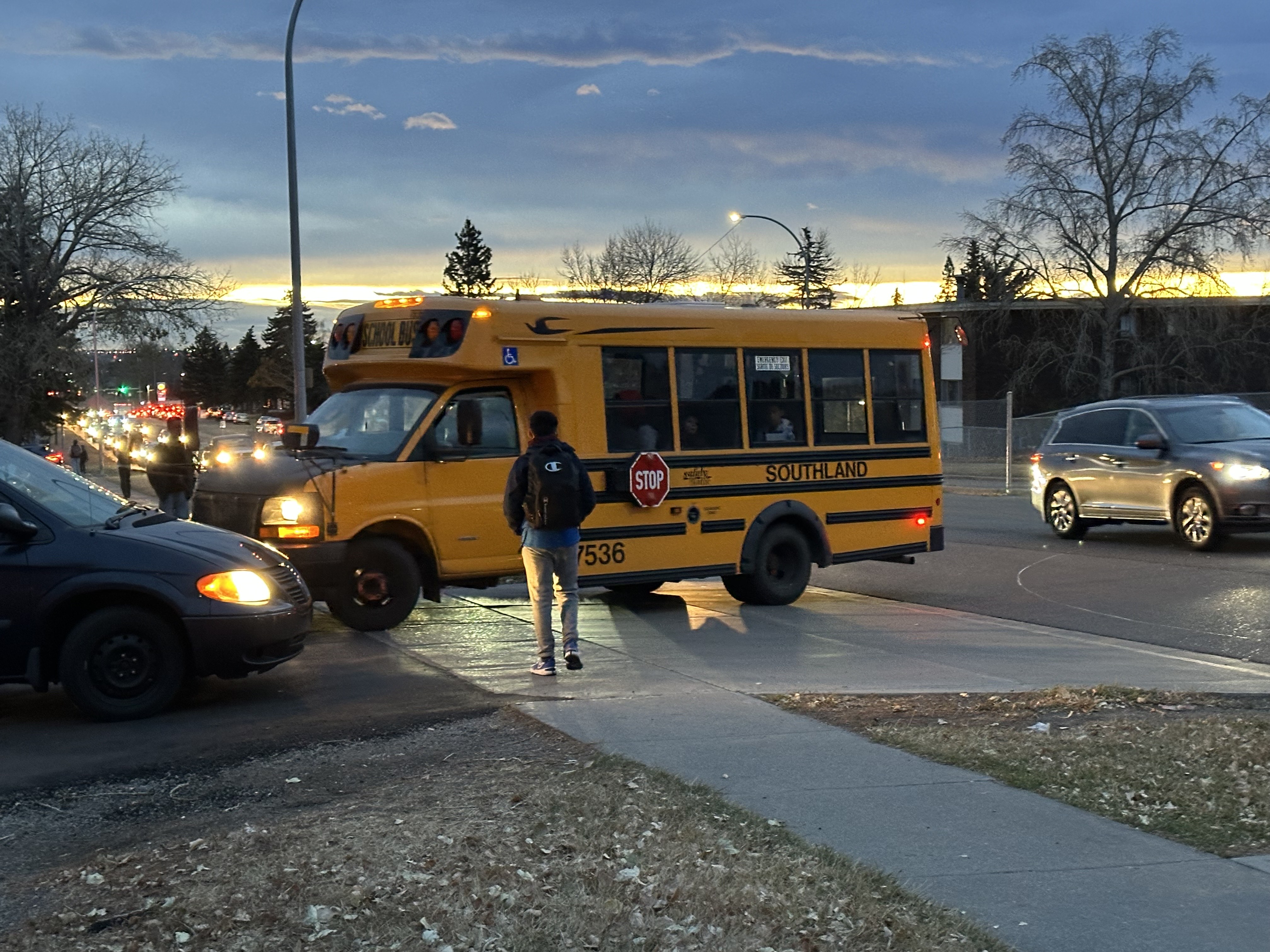 Eligible Alberta parents receive provincial payments Friday for children out of school during teachers' strike; A student walks by a yellow school bus on an early morning