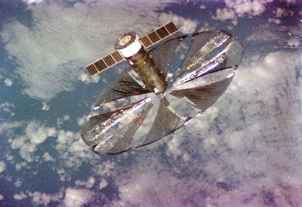 Graudains satelīta attēls ar izvietotu apļveida, spīdīgu materiālu.