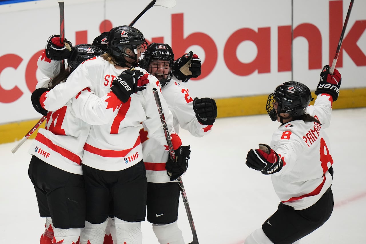 Canadian hockey players celebrate on the ice.