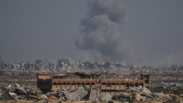 Smoke rises above destroyed buildings.