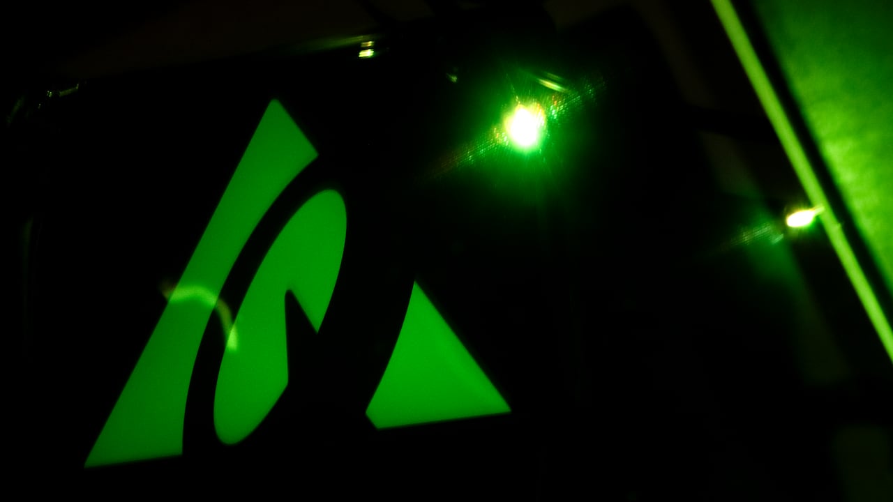 the greenish  triangular questrade logo pictured connected  a achromatic  telephone  screen