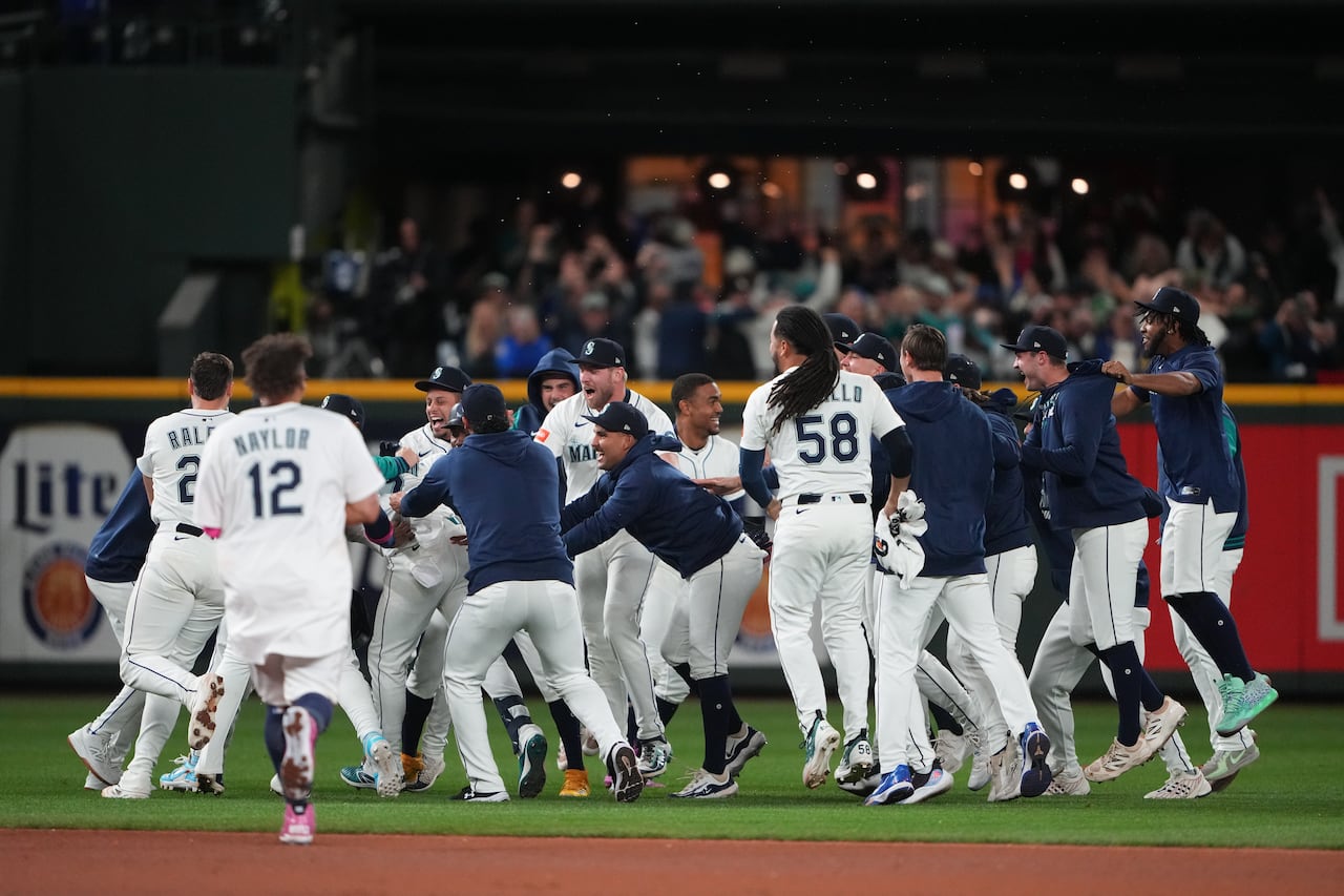 Baseball players celebrate on the field.