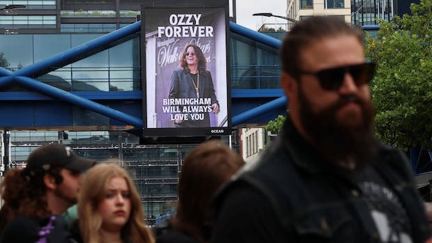 People queue to pay tribute to Ozzy Osbourne, the former Black Sabbath frontman, in Birmingham, Britain, July 30, 2025. REUTERS/Jack Taylor People walk by a large sign of Ozzy Osbourne that says "Birmingham will always love you."