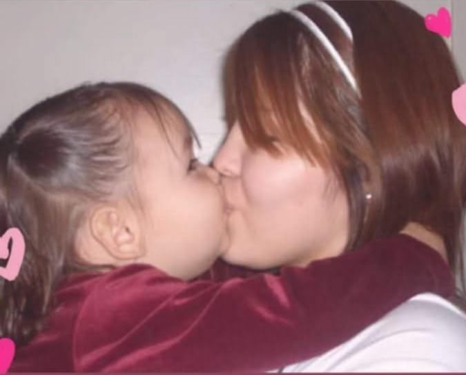 A parent  and her young unneurotic  clasp  each   different   and springiness  each   different   a peck connected  the lips.