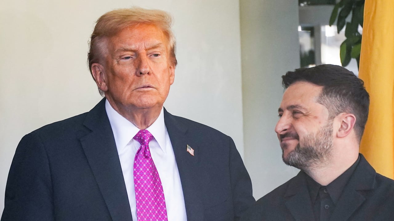 Two men in dark suits stand together