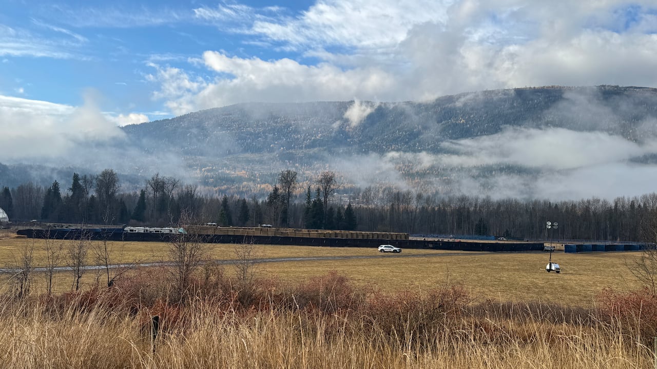 Bails of hay are stacked wrong  a ample  rectangular are lined with achromatic  fences.