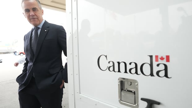 Prime Minister Mark Carney walks by a Canada Border Services Agency vehicle at the Rainbow Bridge border crossing in Niagara Falls, Ont., on Friday, Oct. 17, 2025. THE CANADIAN PRESS/Nathan Denette A man walks by a sign