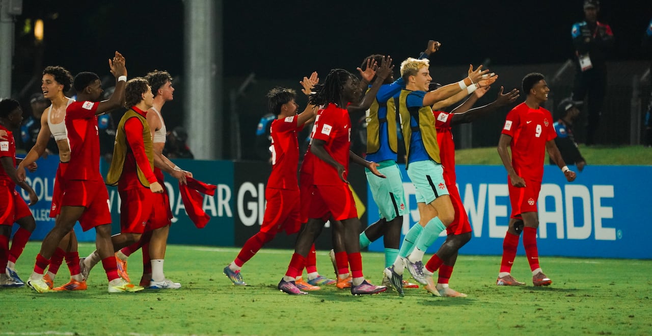 Soccer players representing Canada celebrate following a win.