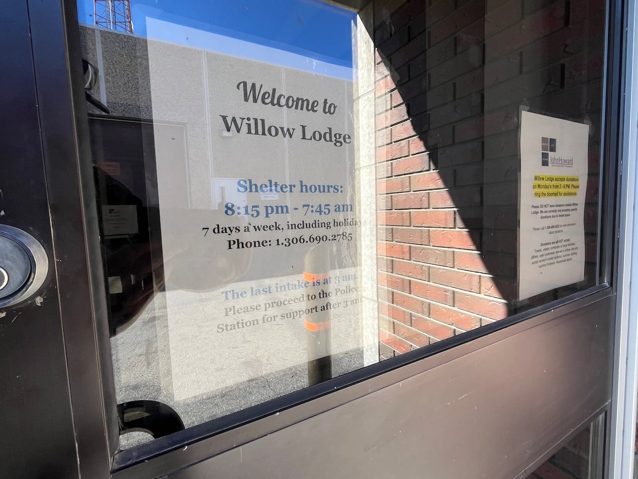 A white paper sign is posted on the interior of a door. 