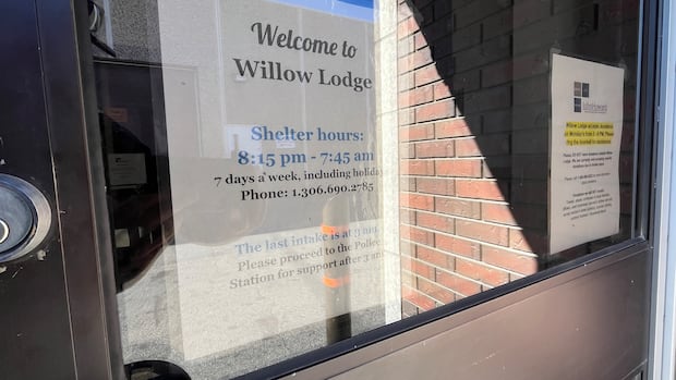 A white paper sign is posted on the interior of a door. 