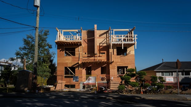 Construction on a multiplex home in the 1000-block of Stratford Ave is pictured in Burnaby, B.C., on Friday, Oct. 17, 2025. Construction underway on a large multiplex home with fencing and wood frame up
