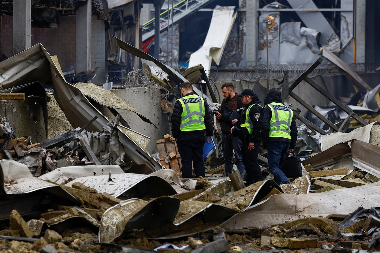 Police investigators stand over the debris.