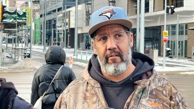 An Edmonton man wearing a baseball hat shares his opinion with a reporter. An Edmonton man shares his opinion with a reporter.
