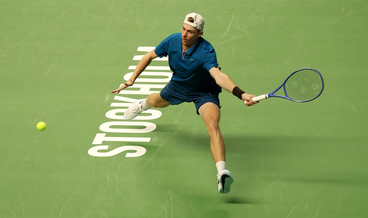 A tennis player plays a forehand during a match.