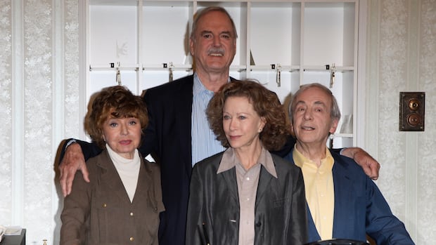 LONDON, ENGLAND - MAY 06:  The original cast of Faulty Towers, Prunella Scales, John Cleese, Connie Booth and Andrew Sachs were reunited to celebrate the 30th anniversary of the programme at The Naval & Military Club on May 6, 2009 in London, England. A special programme "Faulty Towers : Re-opened" will air exclusively on G.O.L.D. on May 10, 2009.  (Photo by Tim Whitby/Getty Images) Two older men and two older women pose for a photograph together. One of the men stands behind the other three with his arms around them.