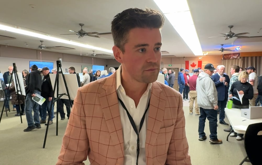 Man lasting  with mic pointed to him with a neutral expression.