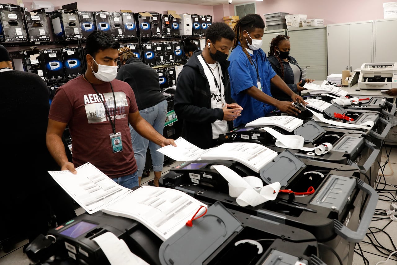 Many people wearing COVID-19 masks are using machines to recover printed paper.