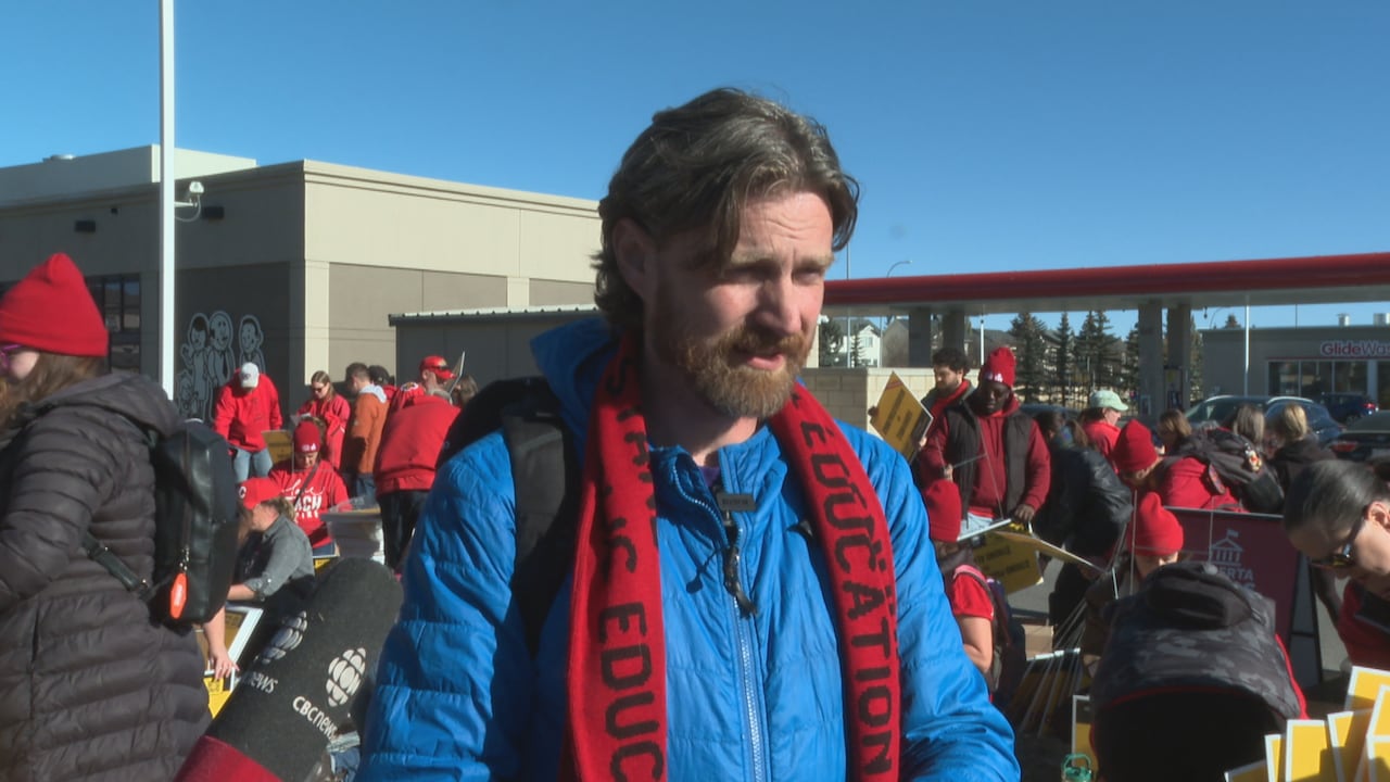 A man in a blue jacket and a red scarf.