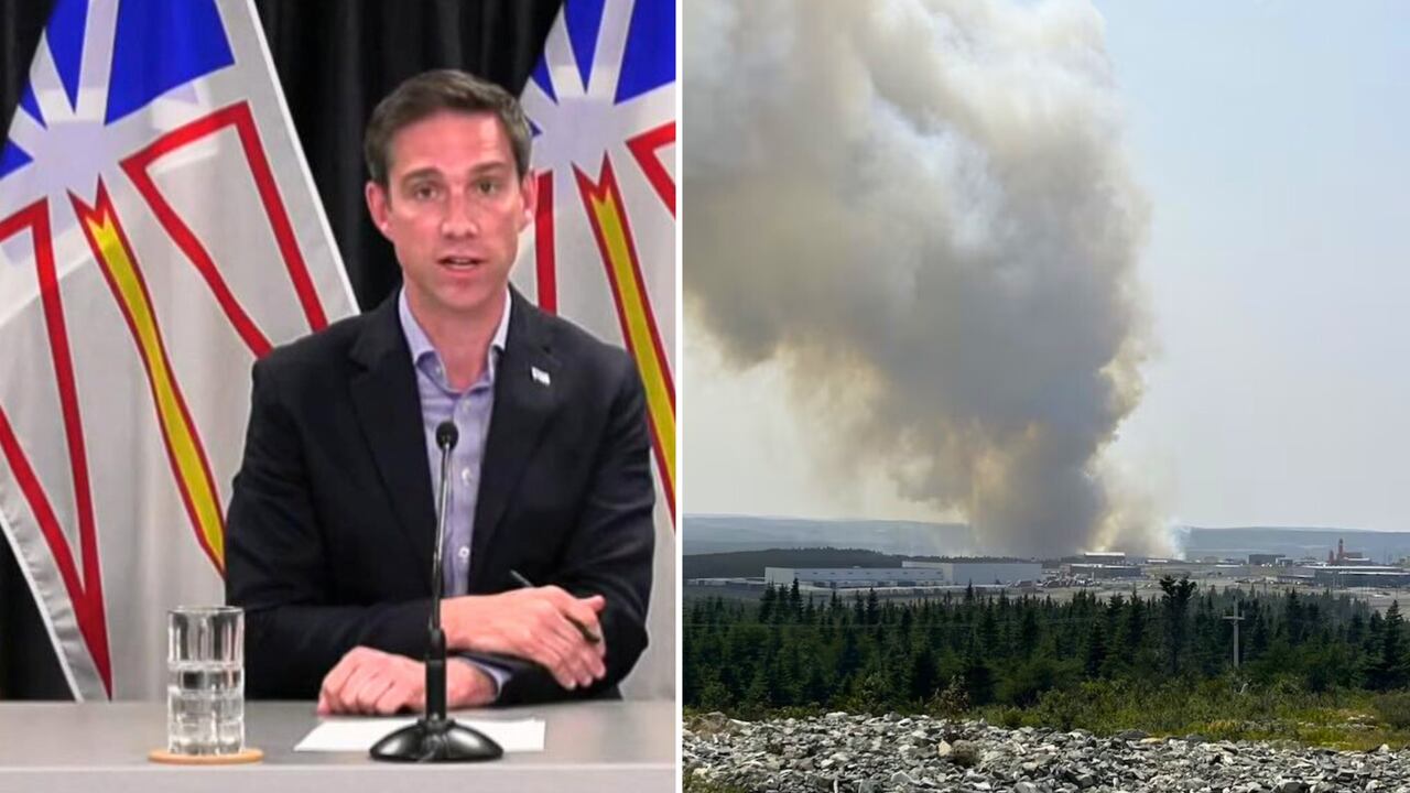 Smoke rises from a distant fire, while Premier John Hogan speaks at a press conference.,
