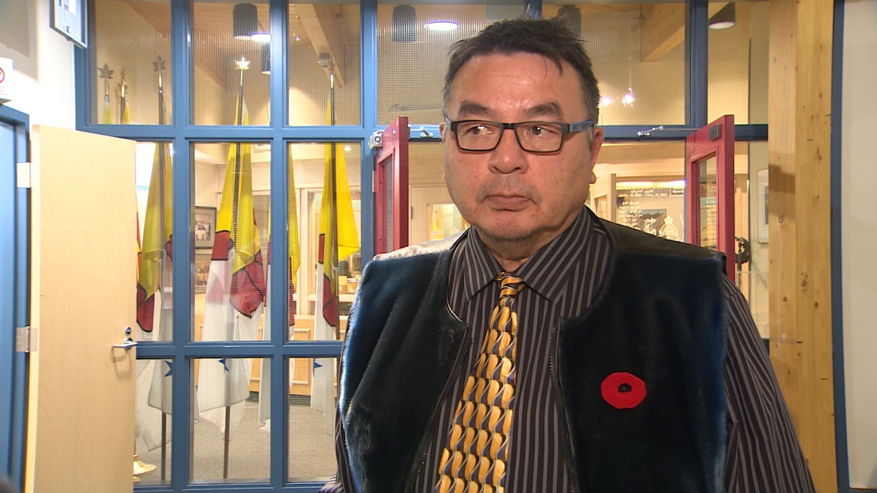 A antheral wearing glasses, a necktie and a vest looks disconnected to the broadside of the camera.